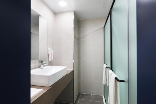 a bathroom with a white sink and a mirror at Mokpo Ocean Hotel in Mokpo