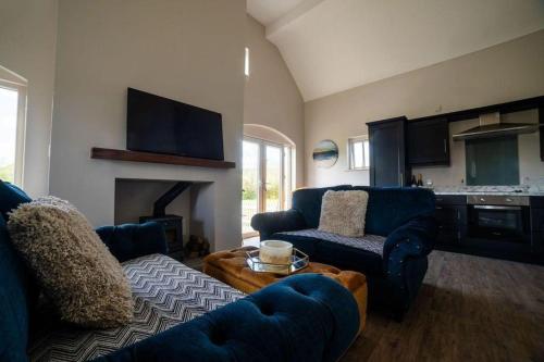 a living room with blue furniture and a fireplace at Cottage 3 Bed Sleeps 7 Free Parking in Enniskillen