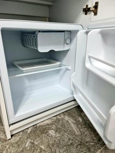an empty refrigerator with its door open in a room at Casa Patry in Călimăneşti