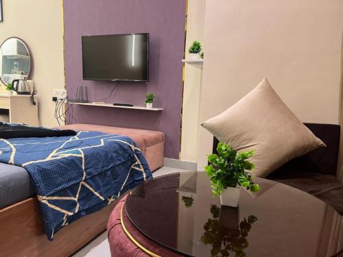 sala de estar con cama, mesa y TV en Ivy Splendour Private Studio B, Oshiwara, en Bombay