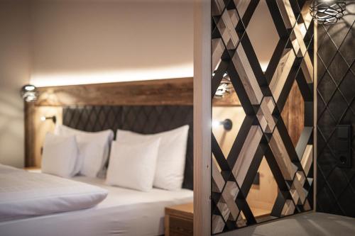 a bedroom with a bed with white pillows at Hotel Alpenblick in Sesto