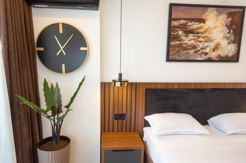 a bedroom with a clock on the wall next to a bed at Apartments Milla in Ulcinj