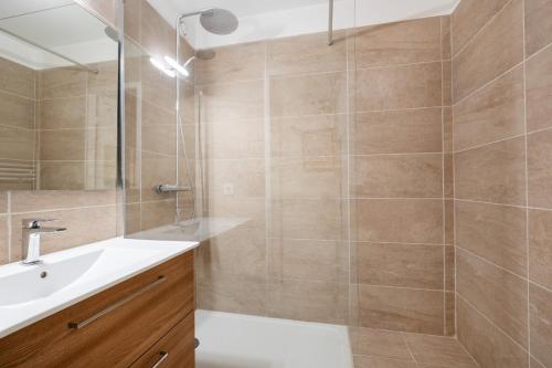 une salle de bain avec un lavabo blanc et une douche dans l'établissement AS23993 - P2 Centre ville - parking privé et wifi, au Grau-du-Roi