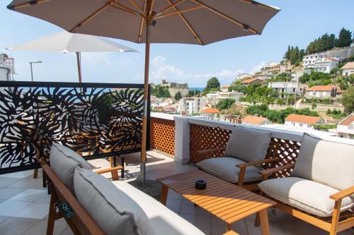 a balcony with two couches and an umbrella at Apartments Milla in Ulcinj