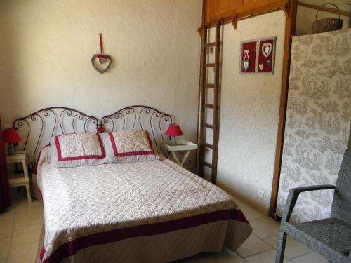 - une chambre avec un lit doté d'oreillers rouges et d'une échelle dans l'établissement Gîtes La Ferme du Bellay - Côté Jardin, à Montreuil-Bellay