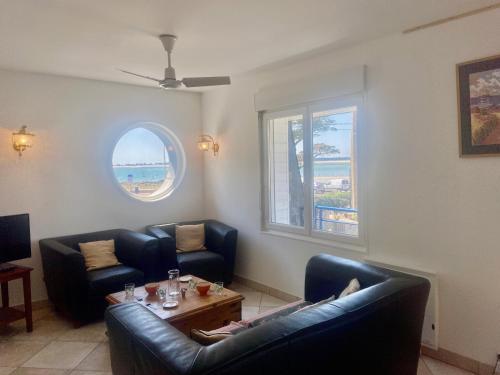 un salon avec deux canapés et une table dans l'établissement CARAVELLE - Vue mer, St Colomban - T16, à Carnac