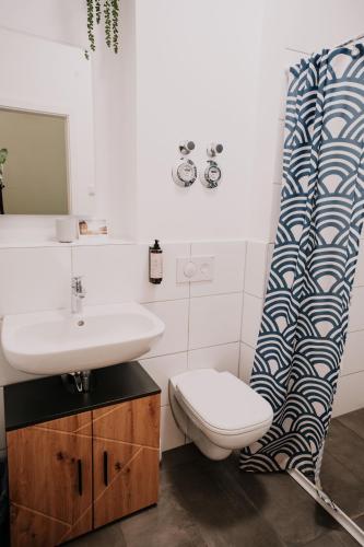 a bathroom with a sink and a toilet and a shower curtain at Gemütliche Ferienwohnung mit direkter Innenstadtlage in Bingen am Rhein