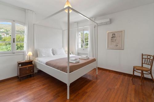 a bedroom with a canopy bed and a chair at Summer Retreat, 50m from Gialia Beach by Explore Andros in Andros