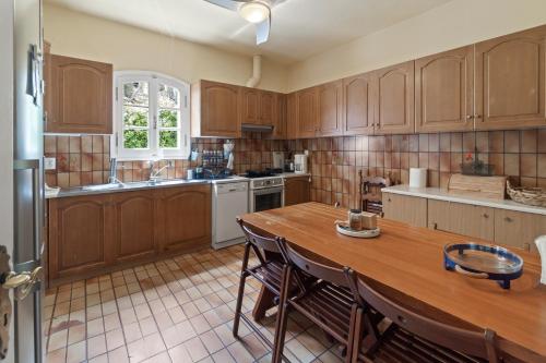 a kitchen with wooden cabinets and a wooden table at Summer Retreat, 50m from Gialia Beach by Explore Andros in Andros