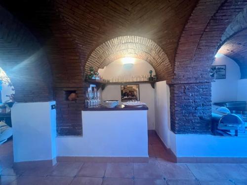 a kitchen with a white counter in a brick wall at Il Borgo nel bosco in Canterano