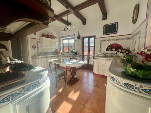 a large kitchen with white cabinets and a table at Il Borgo nel bosco in Canterano