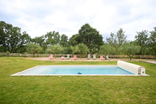 - une piscine au milieu d'une pelouse dans l'établissement La Grange des Aurièges, à Bédarieux