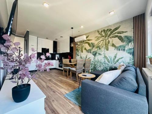 a living room with a blue couch and a kitchen at Apartamenty Dębowa 26 in Milicz