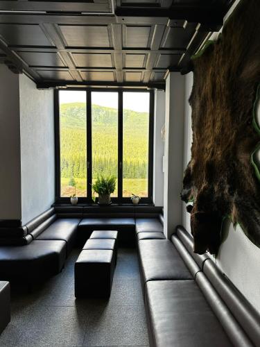 a living room with a couch and a large window at Poarta Raiului in Tău Bistra