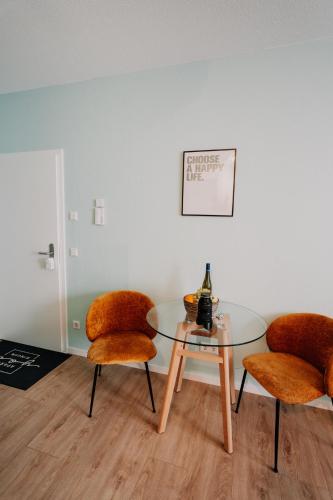 a dining room with two chairs and a glass table at Gemütliche Ferienwohnung mit direkter Innenstadtlage in Bingen am Rhein