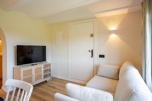 a living room with a white couch and a tv at Picasso Mountain View Begur in Begur