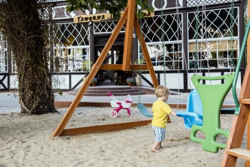 a little boy playing on a swing in the sand at Tawerna Panorama in Stepnica