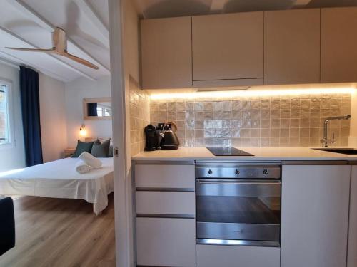 a kitchen with a stove and a bed in a room at Picasso Mountain View Begur in Begur