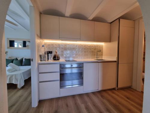 a kitchen with white cabinets and a stove top oven at Picasso Mountain View Begur in Begur