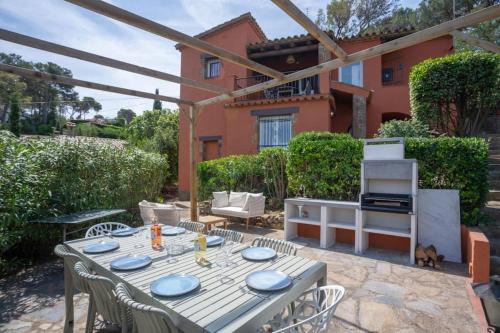 a patio with a table and chairs and a grill at Picasso Mountain View Begur in Begur