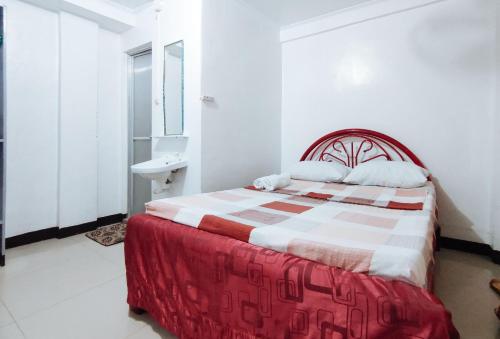 a bedroom with a red and white bed and a sink at Iloilo Paraw Beach Resort in Iloilo City