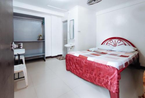 a bedroom with a bed with a red and white blanket at Iloilo Paraw Beach Resort in Iloilo City