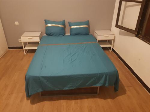 - une chambre avec un lit avec des draps bleus et 2 tables dans l'établissement Apprt'Nadia, à Avignon