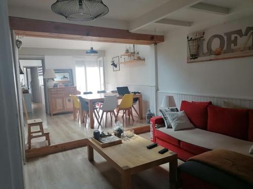 un salon avec un canapé rouge et une table dans l'établissement Maison de vacances, à Rochefort