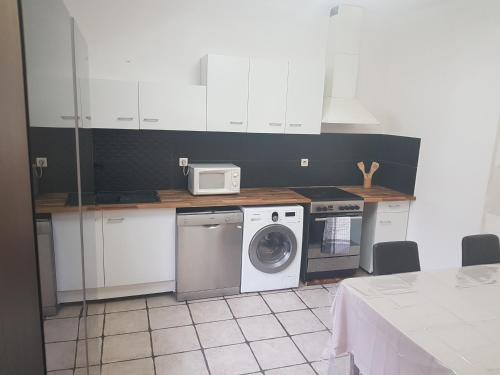 una cocina con lavadora y microondas en Apprt'Nadia, en Aviñón