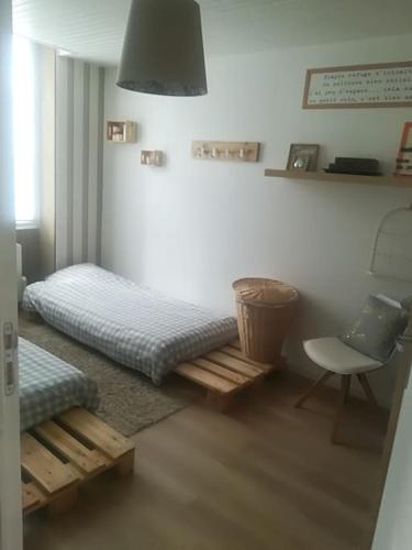 Cette chambre comprend un lit et une chaise. dans l'établissement Maison de vacances, à Rochefort