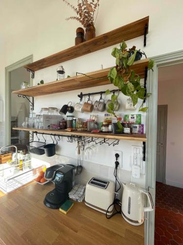 une cuisine avec des étagères, des casseroles et des poêles dans l'établissement La maison du Dragon, à Draguignan