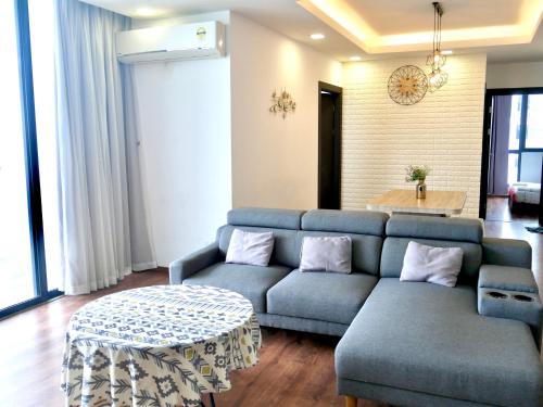 a living room with a blue couch and a table at vivacity megamall jazz suites 2 kuching in Kuching