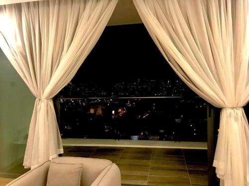 a room with a window with a couch and a view at vivacity megamall jazz suites 2 kuching in Kuching