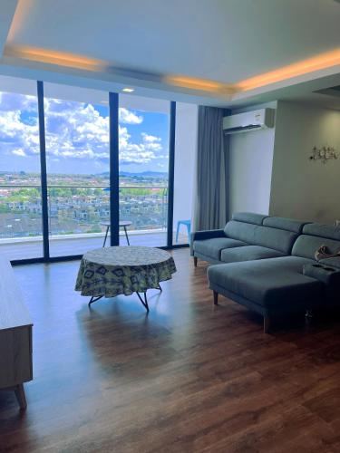 a living room with a couch and a table and large windows at vivacity megamall jazz suites 2 kuching in Kuching