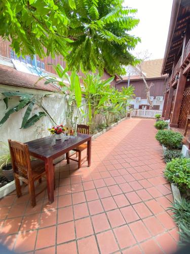 a wooden table and benches on a patio at Luangprabang Villa Kee Lee in Luang Prabang