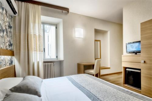 a hotel room with a bed and a television at Hotel Italia in Cagliari