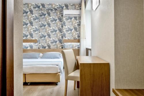 a bedroom with a bed and a table with a chair at Hotel Italia in Cagliari