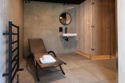 een badkamer met een stoel en een spiegel bij Veluwe Hotel De Beyaerd in Hulshorst