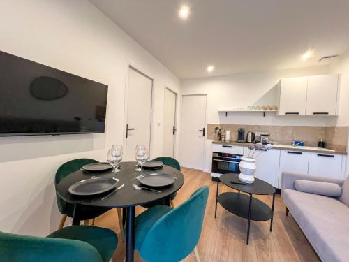 un salon avec une table et des chaises et une cuisine dans l'établissement Syrah Casa Maja - parking privé - tersasse, à Saint-Étienne