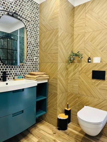 a bathroom with a toilet and a sink and a mirror at Apartamenty Dębowa 27 in Milicz