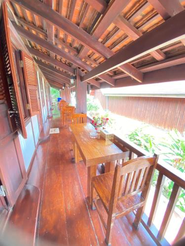 an outdoor patio with wooden tables and benches at Luangprabang Villa Kee Lee in Luang Prabang