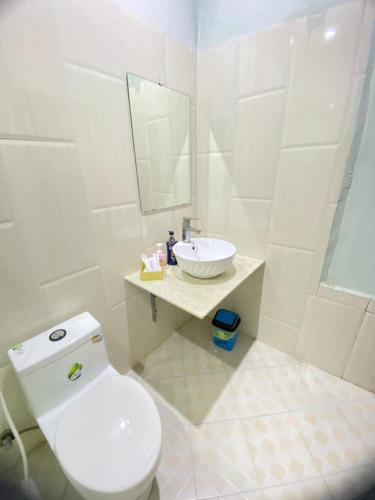 a white bathroom with a toilet and a sink at Luangprabang Villa Kee Lee in Luang Prabang