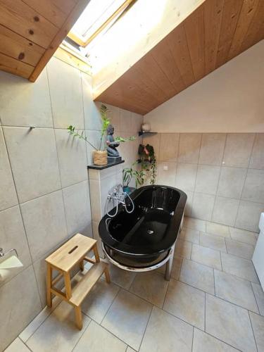 a bathroom with a black bath tub and a table at ThronVomChiemgau in Übersee
