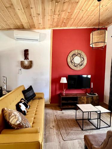 a living room with a couch and a red wall at Hacienda la Yerbabuena in Cádiz