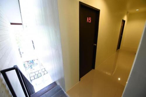 a bathroom with a black door with the number at Kitty Guesthouse in Phi Phi Don