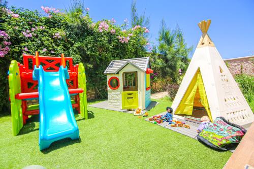 a group of play equipment on the grass at Villa La Rose Bleue - Résidence Hôtelière avec Piscine - Essaouira in Essaouira