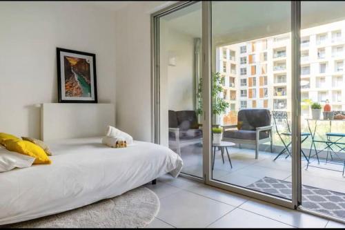 une chambre avec un lit et une porte coulissante en verre dans l'établissement Le Serenity T2, à Aix-en-Provence