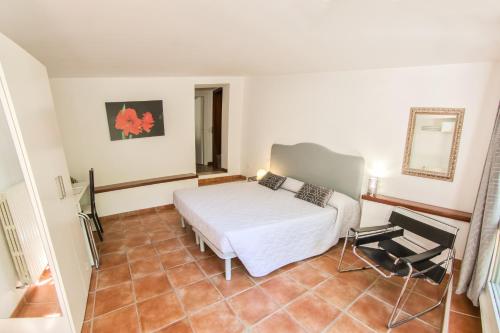 a bedroom with a white bed and a chair at Ai Giardini di San Vitale in Ravenna
