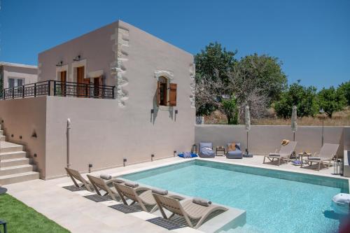 a villa with a swimming pool in front of a house at Pavlina Villa , a hidden gem with heated pool and ping pong! in Perama