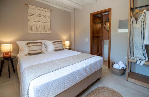 a bedroom with a large white bed and a bathroom at Pavlina Villa , a hidden gem with heated pool and ping pong! in Perama
